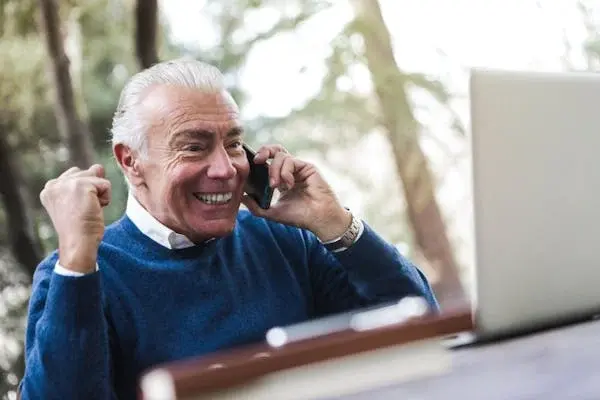 Man in blue sweater in excitement and confidence on a phone call