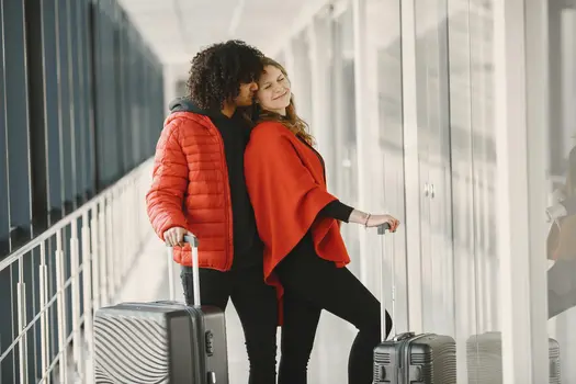Dating as an immigrant Romantic couple travel at airport with suitcases in cozy embrace