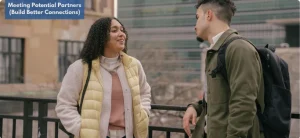 Two people having a friendly conversation outdoors, building rapport ass potential partners.