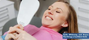 A young woman with a bright smile examining her teeth after braces treatment and whitening at the dental clinic