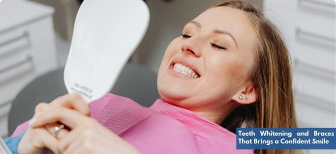 A young woman with a bright smile examining her teeth after braces treatment and whitening at the dental clinic