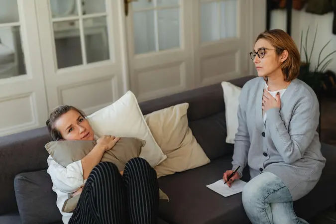 Woman in therapy session preparing for emotionally meeting potential partners, holding a cushion for comfort during emotional processing