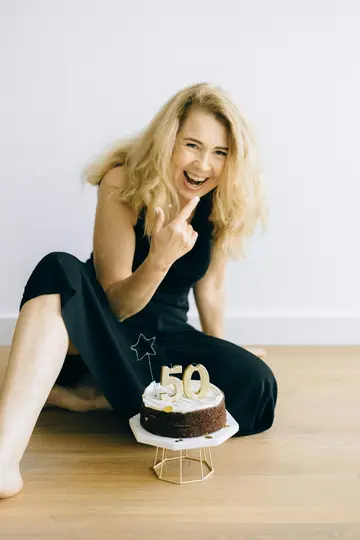 A cheerful woman celebrating her 50th birthday, highlighting how to meet a partner in your 50s through friends