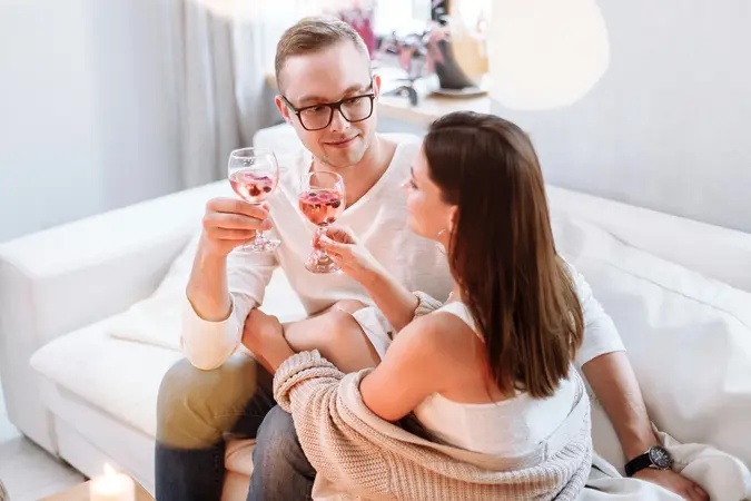A couple enjoying a drink together at home, illustrating how romantic intentions can be misread when meeting potential partners through friends
