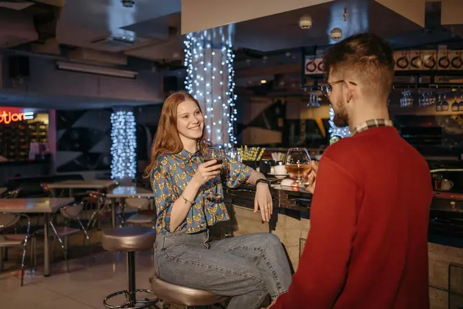 A casual conversation between two people at a bar, representing feelings pitfall of meeting potential partners through friends in social settings.